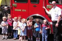 Fire Chief Stanton teaching some preschoolers about home safety and 911 recognition and activation